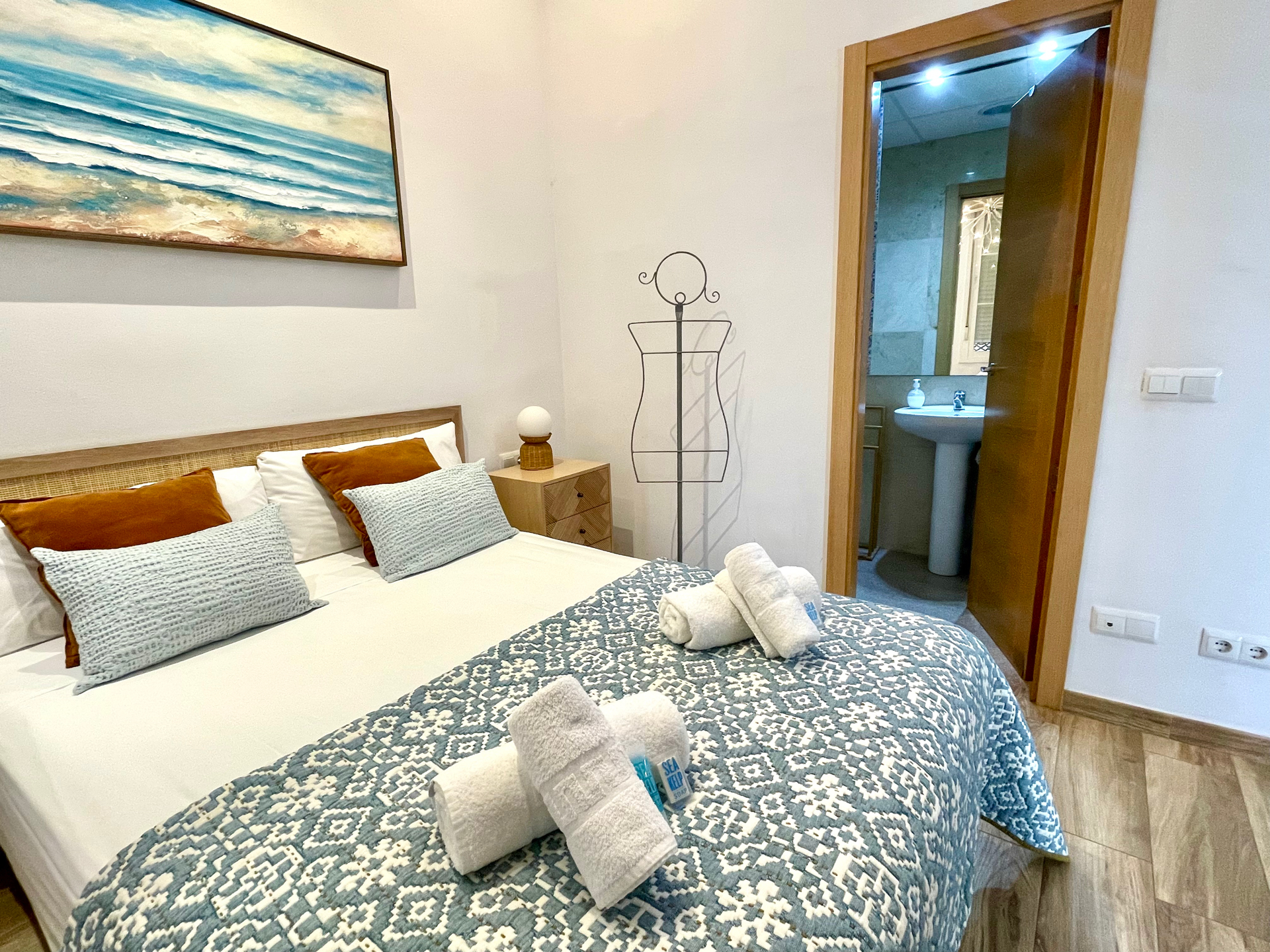 Interior elegante de un apartamento boutique en Málaga con grandes ventanales, muebles modernos con estilo y luz ambiental cálida
