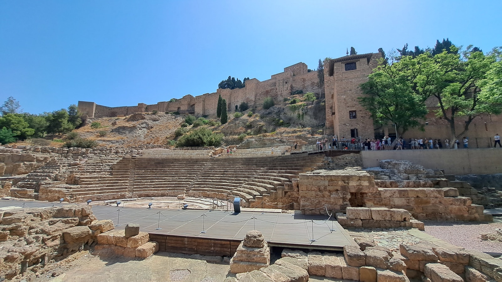 Murallas de la Alcazaba alzándose sobre el Teatro Romano de Málaga a la hora dorada
